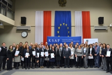 Zdjęcie grupowe na tle flag Polski i UE