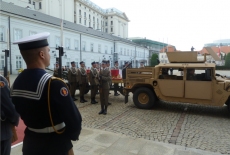 Trumna wnoszona jest do samochodu. Obok stoją żołnierze.