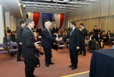 Widok na aule Dyrektor Jacek Czaputowicz wręcza dyplom jednemu z absolwentów, obok stoi Leszek Balcerowicz